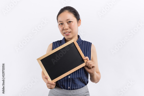 Portrait of a playful red hair business woman holding a shalk board over white wall background. photo