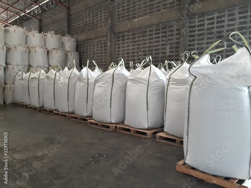 White hemp sacks containing chemical fertilizer Large yellow-green sidebar placed on wooden pallets. To wait for delivery to customers