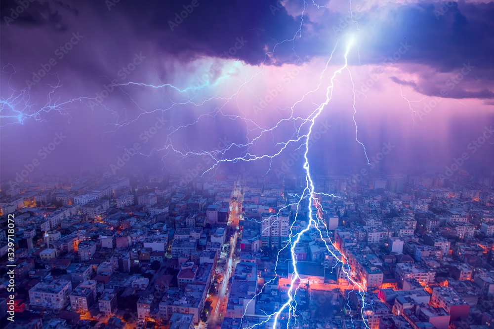 Lightning thunderstorm flash over the city at blue night sky Lightning storm over city in blue