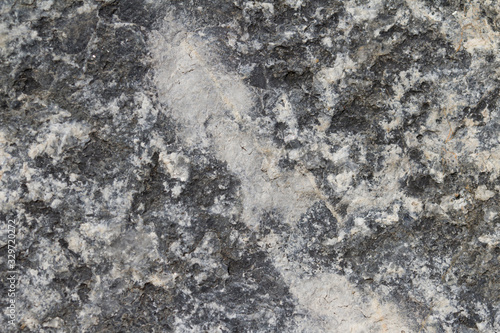 Surface grey granite stone with light lines and streaks.