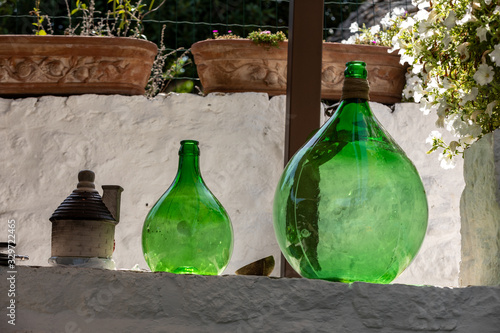 Alberobello, Italy - Septembet 16, 2019: Demijohn wine bottles at cafe in Trulli village in Alberobello, Italy. photo