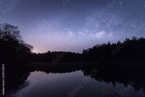 View of the reflection of the lake with milky way at dawn in Chiang Rai, Thailand.