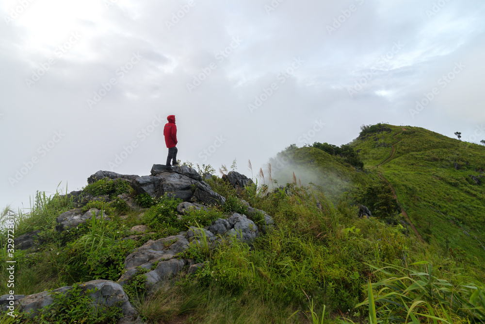 Fototapeta premium View of a man stand on the top of the peak of Pha Tang in Chiang Rai, Thailand.