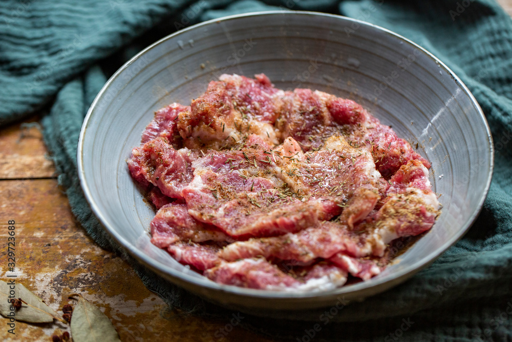 Fresh-marinated raw steak with Vanilla and pepper in bowl on wooden background.