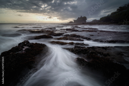 Beautiful view of long exposure of Pura Tanah Lot in sunset time at Bali, Indonesia.