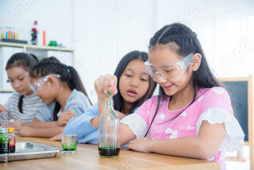 Group of young asian schoolgirls doing experiment in chemistry classroom. © gamelover