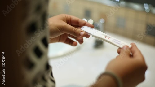 Close Up Tracking Of Woman Holding Positive Pregnancy Test In Public Bathroom