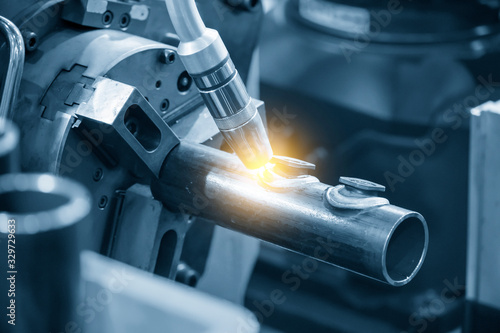 The automatic robotic system welding the metal pipe parts with the special nut .  The hi-technology automotive parts assembly processing by robotic arm control by CNC program.