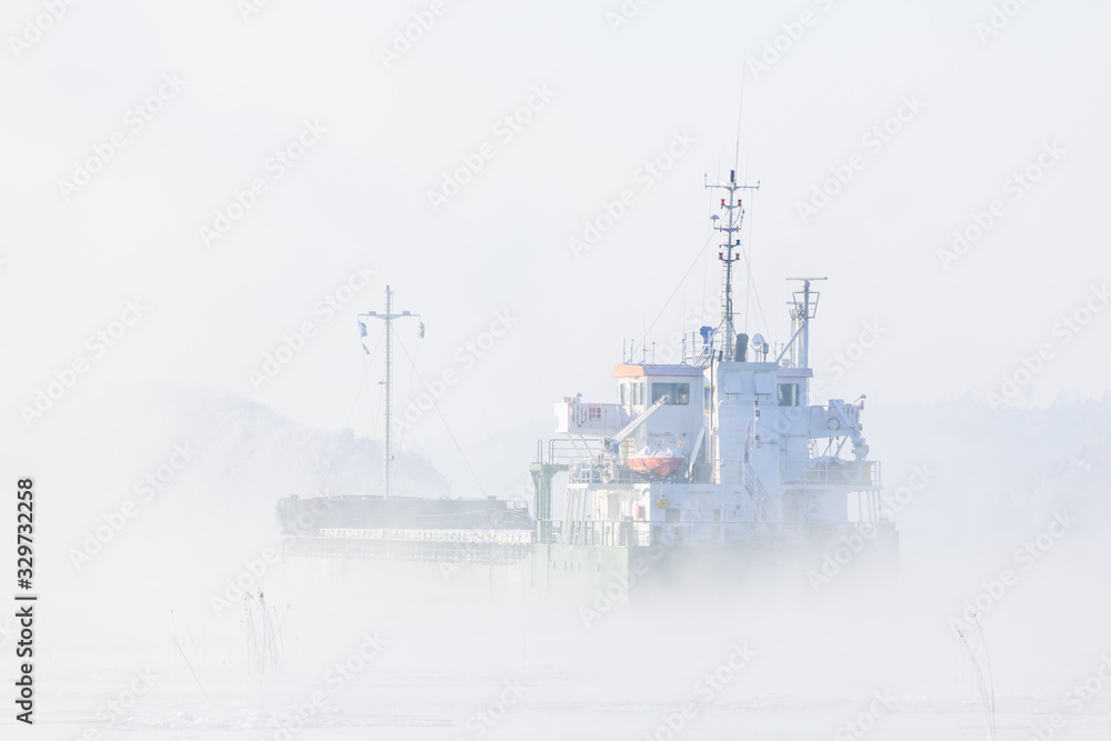 Fototapeta premium Freight boat in mist. Göta Älv river, Sweden