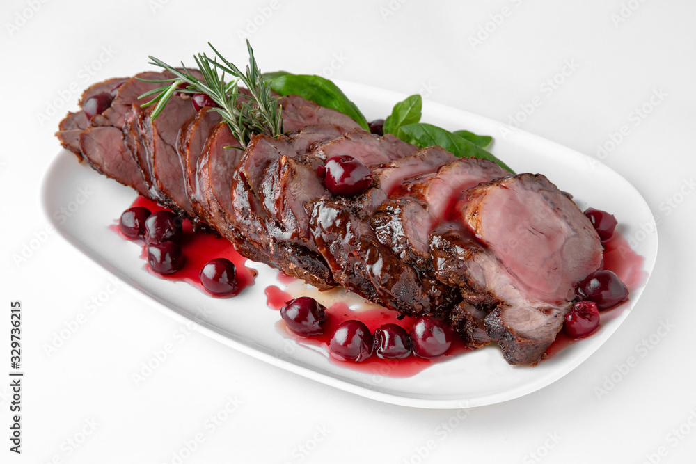 Sliced pork or beef tenderloin baked in cherry sauce. Banquet festive dishes. Gourmet restaurant menu. White background.