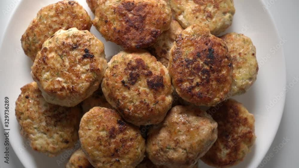 Pile of fried chicken cutlets on plate rotating in microwave top view. Pile of fried chicken cutlets on plate rotating in microwave top view.