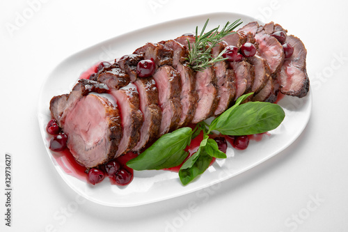Sliced pork or beef tenderloin baked in cherry sauce. Banquet festive dishes. Gourmet restaurant menu. White background.