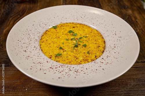 Close up and over a plate of risotto with saffron, white plate on a rustic table