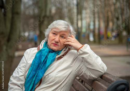 Horizontal portrait of an elderly gray- haired elegantly dressed woman