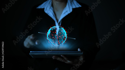 фотографія Business woman using a tablet computer, with hologram futuristic globe sphere, t