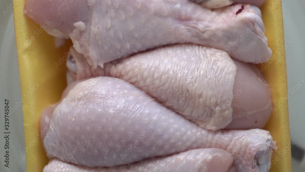 Fresh raw chicken drumsticks in food tray rotating in microwave top view. Fresh raw chicken drumsticks in food tray rotating in microwave top view.