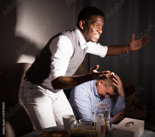 Male friends watching football match on tv  and having fun photo