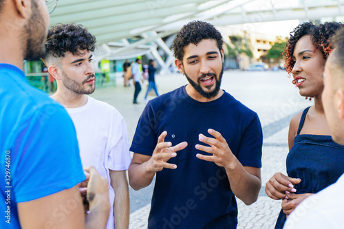 Fotografie Young mix raced man telling exciting funny story to his friends