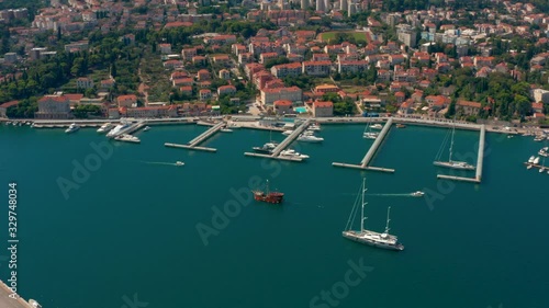 Right pan aerial shot following a new and a old sailing boats in Dubrovnik port photo