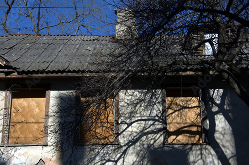 clogged windows of an old crumbling house