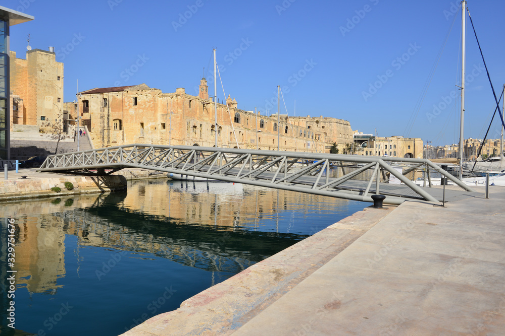  Lattice framed bridge in front of a an old harbour at Bormla  in Malta.