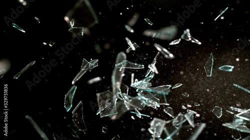 Profile view of Glass breaking in slow motion on black background