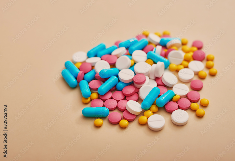 Assorted pharmaceutical medicine pills, tablets and capsules on beige background. Heap of various pills. Coronovirus, quarantine, epidemic, pandemic, flu, cold,illness. Medicine concept and health