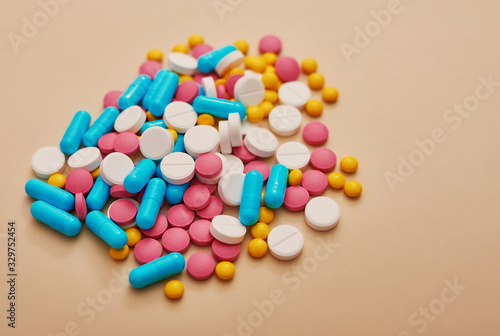 Assorted pharmaceutical medicine pills, tablets and capsules on beige background. Heap of various pills. Coronovirus, quarantine, epidemic, pandemic, flu, cold,illness. Medicine concept and health