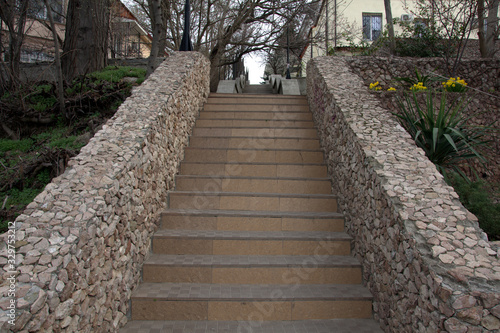 concrete staircase with fences made of small wild stone