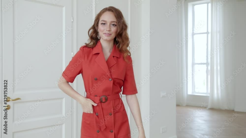 girl with red hair, in a red coat, against a background of white doors, apartment girl with red hair, in a red coat, against a background of white doors, apartment