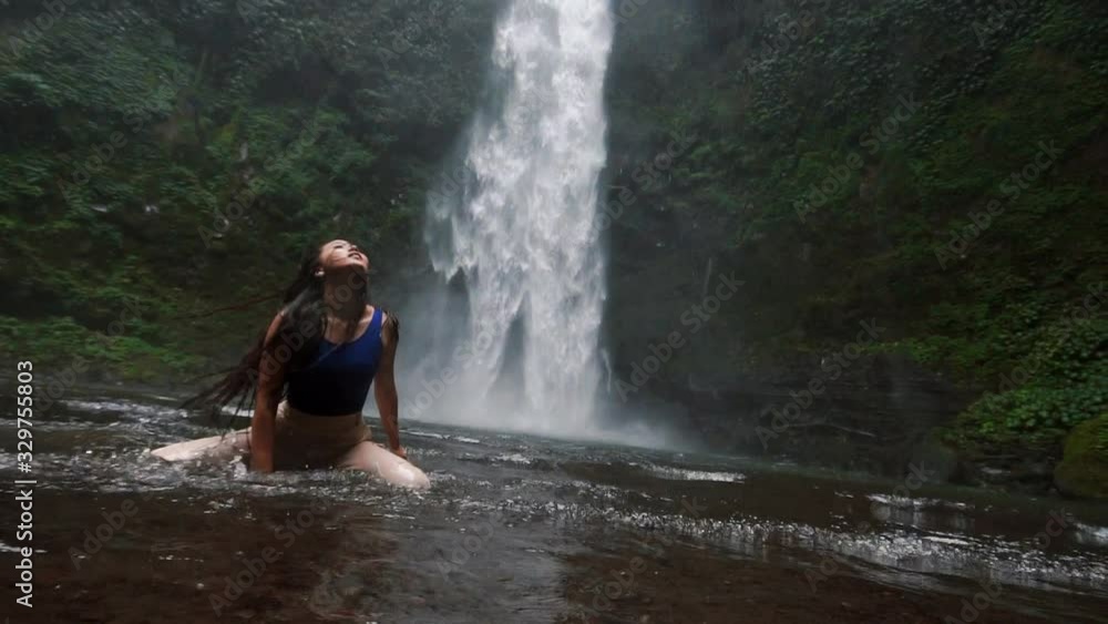 The girl is dancing beautifully in front of a gorgeous and large waterfall in Bali 3rd part The girl is dancing beautifully in front of a gorgeous and large waterfall in Bali 3rd part