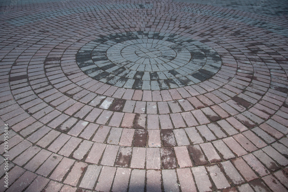 The colored tiles are arranged in a circle. The colors are gray and pinkish. The colored tiles are arranged in a circle. The colors are gray and pinkish.