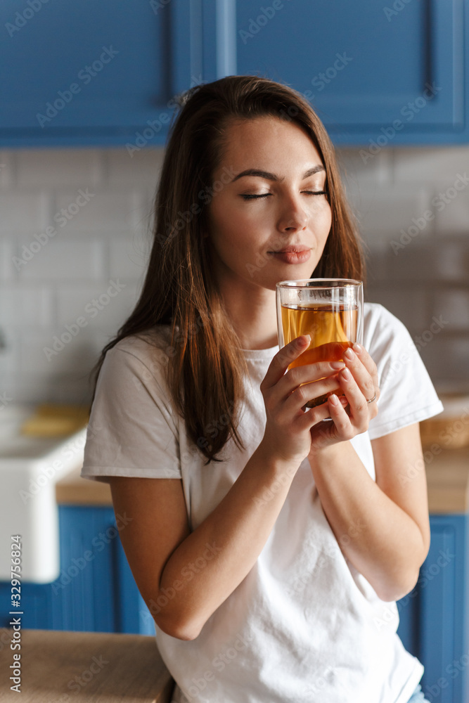 Image of relaxed beautiful woman drinking tea with eyes closed Image of relaxed beautiful woman drinking tea with eyes closed
