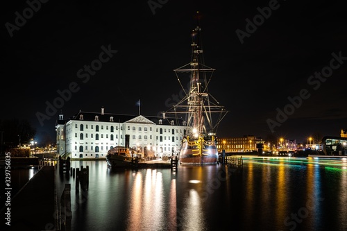 Photography Closeup shot of the National Maritime Museum of Amsterdam at night surrounded wi