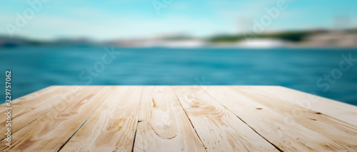 Wooden empty surface on bokeh blue sea background in afternoon.