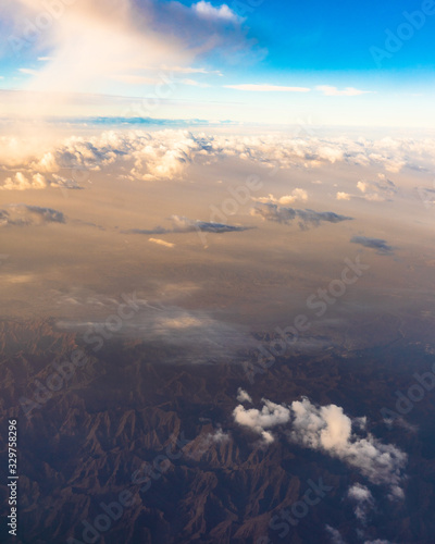 Cuadro en lienzo Aerial view of clouds and mountains landscape from airplane window seat