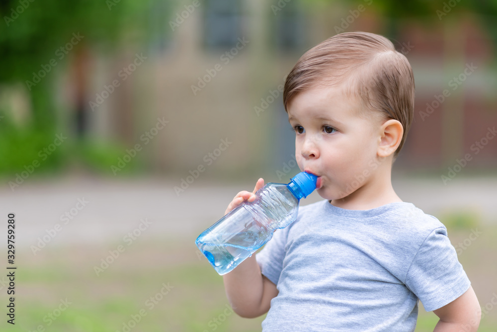 child drinks water from a bottle on a hot summer day child drinks water from a bottle on a hot summer day