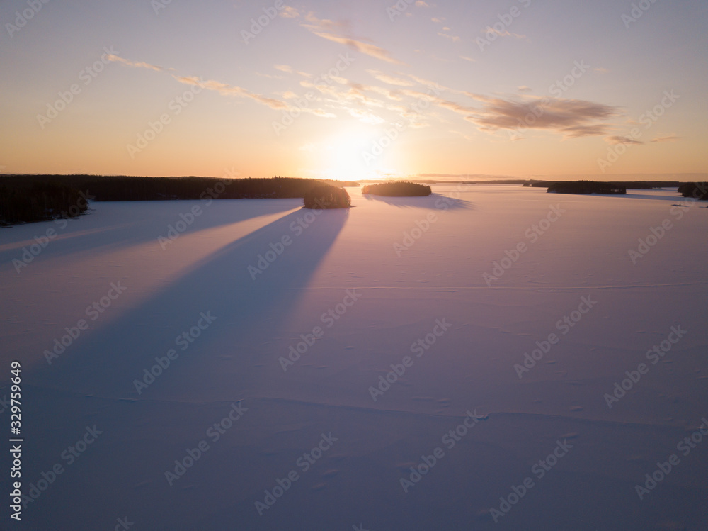 Sunrise behind snowy frozen lake, in winter morning Sunrise behind snowy frozen lake, in winter morning