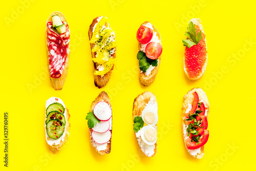 Sandwiches assorti pattern on yellow background top-down