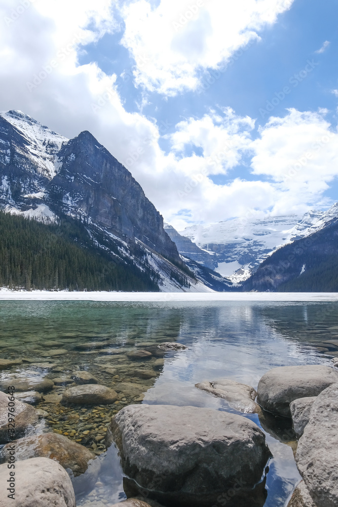 Mount fairview, partly frozen lake, rocks in foreground. Lake Louise Banff National Park, Alberta Canada