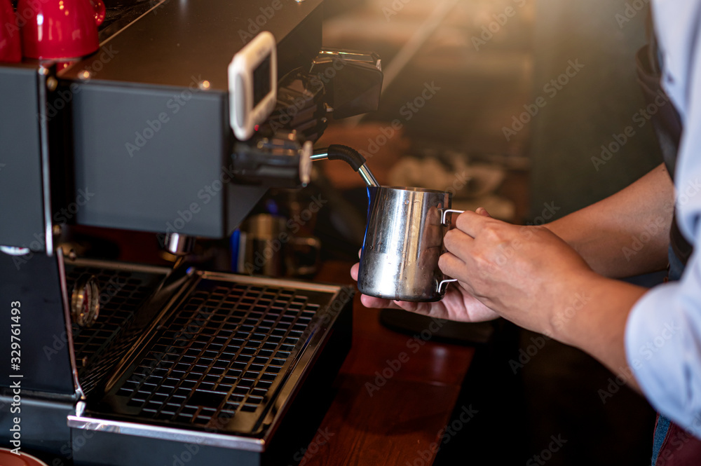 The barista making milk froth