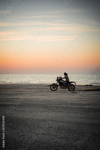Masirah Island, Oman, January 1, 2020: Man on a motorcycle on the beach at sunset