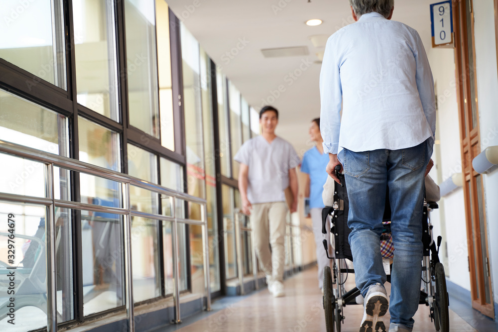employee and residents walking in hallway of nursing home employee and residents walking in hallway of nursing home