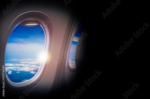 Black background with copy space look of window seat frame of airplane flight see view of clouds sky  wing travel during coronavirus risk crisis fall demand of flight cancel