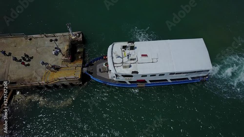 Aerial view of people disembarking the commuter ferry as it stops at Pak Kok on Lamma island, connecting Yung Shue Wan with Aberdeen on Hong Kong island in the SAR of Hong Kong, China. photo