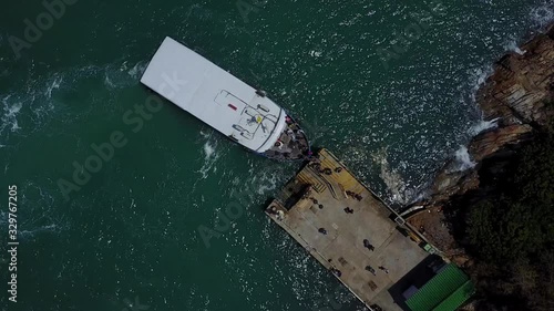 Aerial view of people disembarking the commuter ferry as it stops at Pak Kok on Lamma island, connecting Yung Shue Wan with Aberdeen on Hong Kong island in the SAR of Hong Kong, China. photo