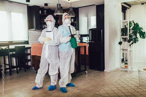 Specialists in protective suits do disinfection or pest control in the apartment.