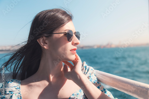 Attractive brunette young woman looking to horizon with her sunglasses copy space
