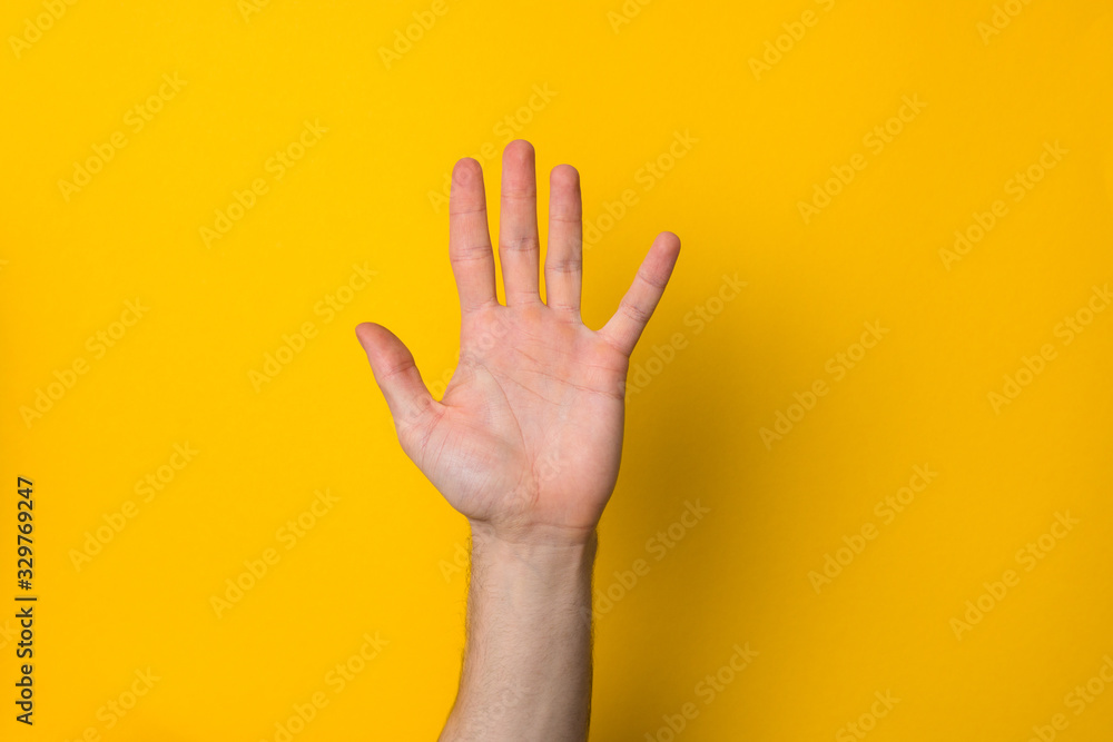 man hand up over a yellow background with copyspace for advert banner man hand up over a yellow background with copyspace for advert banner