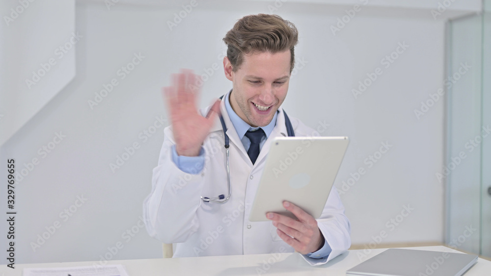 Young Male Doctor doing Video Chat on Tablet in Clinic